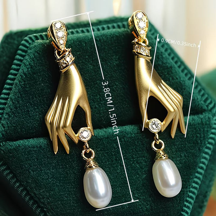 Perlenohrringe mit eleganter Hand